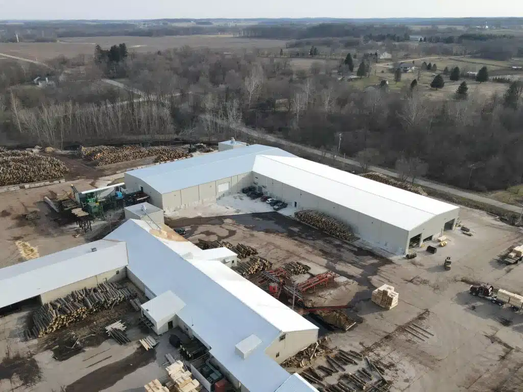 Aerial view of Buskirk Lumber's Freeport, Michigan sawmill. Outside, hardwood timber logs are stacked for processing.